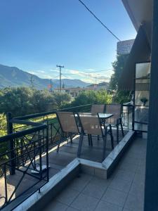a patio with a table and chairs on a balcony at Letsios Steel2 in Kalabaka