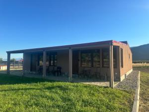 a building with tables and chairs in a field at Letsios Steel3 in Kalabaka