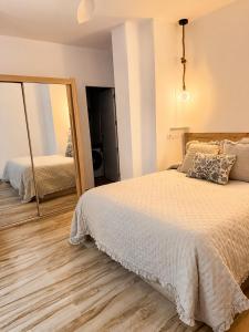 a bedroom with a large bed and a mirror at Casa Pedro in Almodóvar del Río
