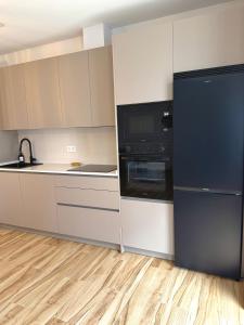 a kitchen with white cabinets and a black refrigerator at Casa Pedro in Almodóvar del Río