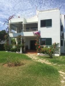 a white house with flowers in the yard at Villa independiente con acceso a la playa in Son Xoriguer