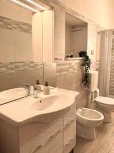a white bathroom with a sink and a toilet at Mimmo Wanderlust in Mazzeo +4 photos