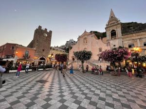 a group of people walking around a plaza in a city at Mimmo Wanderlust in Mazzeo