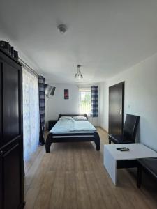a bedroom with a bed and a couch and a table at U Piotra in Sarbinowo