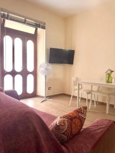 a living room with a table and a tv at Mimmo Wanderlust in Mazzeo