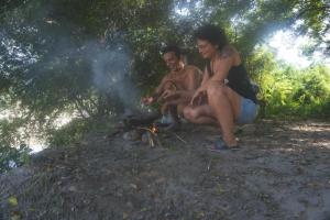 a couple of people sitting around a fire at Raíces del Obrero in Honda