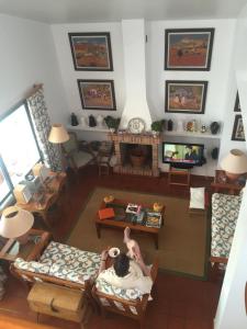 una persona sentada en una silla en una sala de estar en Villa Menorquina, en Son Xoriguer