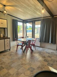 a dining room with a table and chairs and windows at Letsios Steel3 in Kalabaka