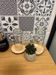 a table with two glasses and a potted plant on it at Petit cocon cosy proche place Stanislas-Parking & cave vélos in Nancy +83 photos