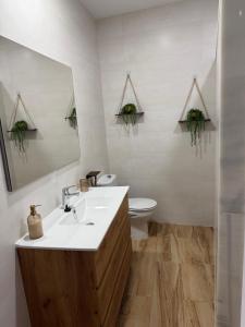 a bathroom with a sink and a toilet and a mirror at Casa Pedro in Almodóvar del Río