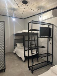 a room with a bunk bed and a television at Letsios Steel3 in Kalabaka