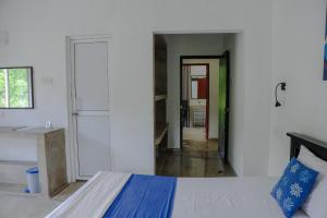 a white room with a bed and a refrigerator at Everdew Kandy Rooms in Kandy