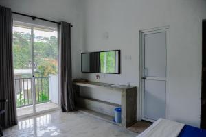 a living room with a television and a balcony at Everdew Kandy Rooms in Kandy +84 photos