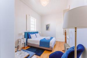 a bedroom with a bed and a chair and a lamp at Galricho Heritage House in Murtosa +39 photos
