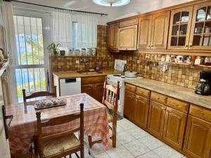 a kitchen with wooden cabinets and a table with a tablecloth at Elenas house in Kánithos