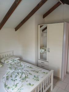 a white bedroom with a bed and a mirror at Le Paradis in Capesterre-Belle-Eau