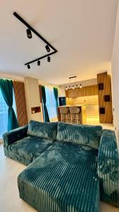 a living room with two green couches in a room at River View Penthouse & Jacuzzi in Reghin