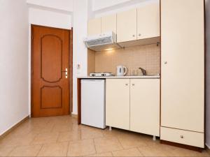 a kitchen with white cabinets and a brown door at Gallery in Ammouliani +13 photos