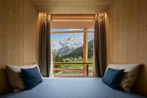 a bedroom with a large window with a mountain view at Hotel Bella Vista in Trafoi +91 photos