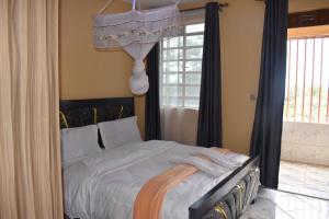 a bedroom with a bed with white sheets and a window at Unique Place 1 Bedroom Thika in Thika