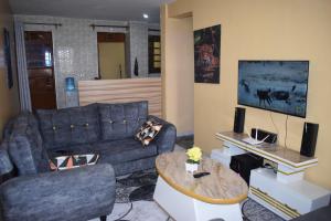 a living room with a blue couch and a table at Unique Place 1 Bedroom Thika in Thika