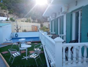 a patio with chairs and a table on a porch at Dina Apartments Kokkari, Pension Dina, Dina Rooms in Kokkari