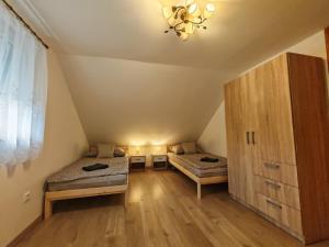 a room with two beds in a attic at Napsugár Vendégház Velence in Velence