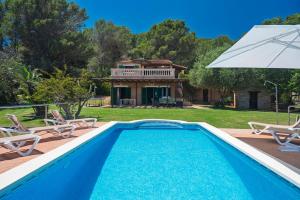 a swimming pool in front of a house at Maricel in Cala Ratjada