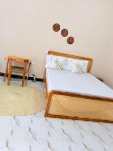 a bed in a room with two rugs and a table at Rocky Apartment Zanzibar in Zanzibar City