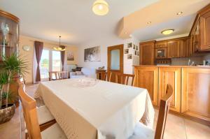 a kitchen and dining room with a white table in a room at Apartman Pina in Vrbnik