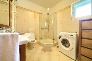 a bathroom with a washing machine and a washer at Apartman Pina in Vrbnik