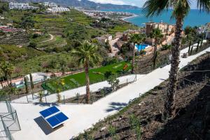a view of a park with palm trees and the ocean at Bayview Hills Apartamento Andaluz in Torrox