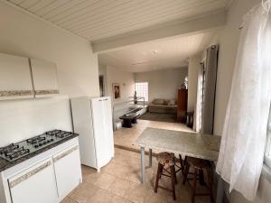 a kitchen with a refrigerator and a table in a room at Morada Pé de Laranja in Lages