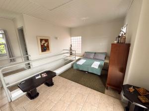 a room with a bench and a bed in it at Morada Pé de Laranja in Lages +13 photos