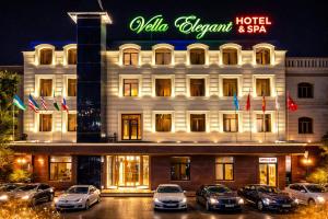 a hotel with cars parked in front of it at Hotel Elegant 2 in Andizhan