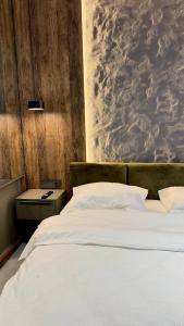 a bedroom with a white bed with a painting on the wall at River View Penthouse & Jacuzzi in Reghin +3 photos