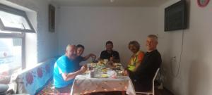 a group of people sitting around a table eating at Алима in Ottuk +1 photo
