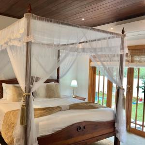 a bedroom with a canopy bed with white curtains at Gedara Boutique in Katunayaka +49 photos