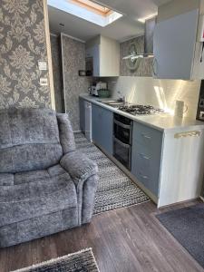 a living room with a couch and a kitchen at Luxury 2 Bed Caravan With Decking - Sleeps 4 - at Broadland Sands Park in Lowestoft