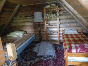 a bedroom with two beds and a lamp in a attic at Pähnamäe metsamajake in Ruusmäe