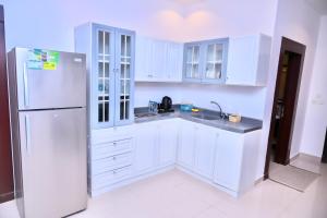 a white kitchen with white cabinets and a refrigerator at روعة نجد المغرزات in Riyadh