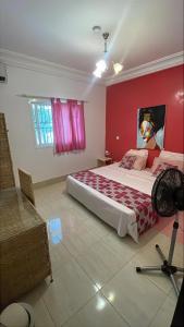 a bedroom with a large bed with a red wall at B & B Villa Calliandra in Bijilo