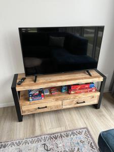 a flat screen tv on a wooden entertainment center at Maristella 332 in Hindeloopen