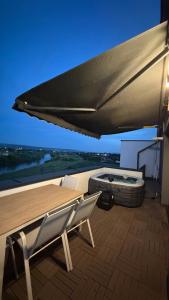 a patio with a table and two chairs and a grill at River View Penthouse & Jacuzzi in Reghin