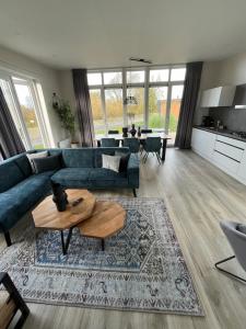 a living room with a blue couch and a table at Maristella 332 in Hindeloopen