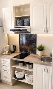 a kitchen with white cabinets with baskets and a sink at Modi Line Vee in Valga