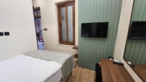 a bedroom with a bed and a flat screen tv at Konak 83 in Nicosia +41 photos