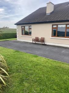 a bench sitting in front of a house at Islandview House in Clonbur