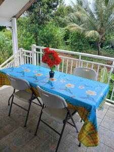 a blue table with a vase of flowers on a patio at Le Paradis in Capesterre-Belle-Eau