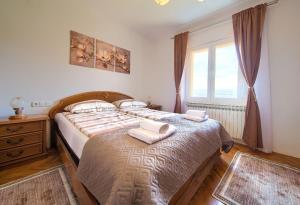 a bedroom with a bed with two towels on it at Apartman Pina in Vrbnik